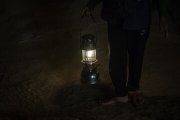 A man with a lamp in the dark, in cave