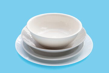 Stack of dishes and bowl on blue background.