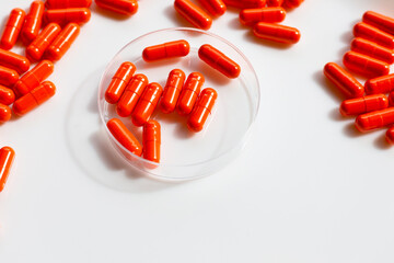 Orange capsule pills on white background.