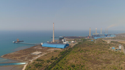 Fototapeta na wymiar power station by sea with smoking pipes, paiton java, indonesia. aerial view power plant in asia.