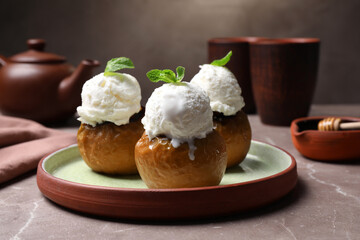 Delicious baked apples with ice cream and mint served on grey table