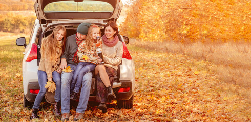 Family resting in car trunk