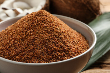 Natural coconut sugar in ceramic bowl on table, closeup