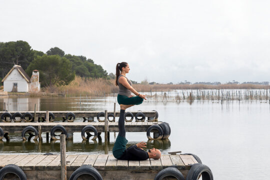 Couple practicing acroyoga in a pier