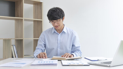 Fototapeta premium Businessman presses a calculator to calculate earnings and analyze company earnings in his private office, Information in finance and accounting, Company performance and revenue.