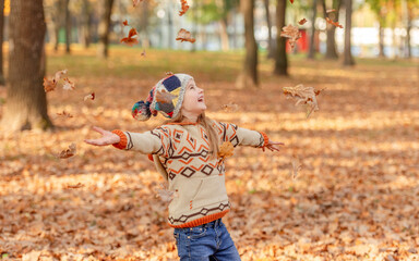 Little girl throwing up leaves