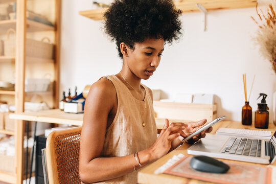 Jewelry designer using phone and laptop - Powered by Adobe