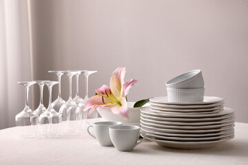 Set of clean dishware and wine glasses on table indoors