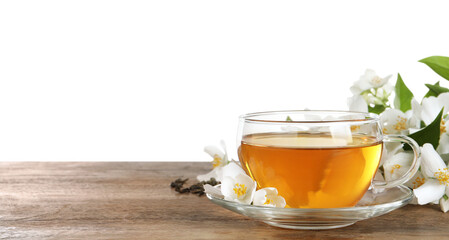 Glass cup of aromatic jasmine tea and fresh flowers on wooden table against white background. Space for text