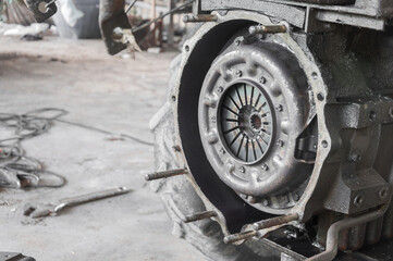 Mechanic repairing disassembled engine. Old tractor  is working with a tractor engine in a garage