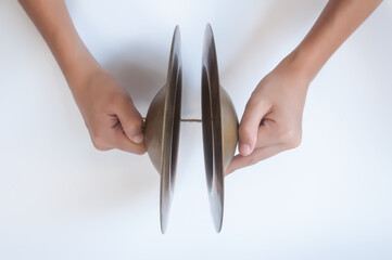 Hand holding cymbals, an old Thai musical instrument isolated on white background.