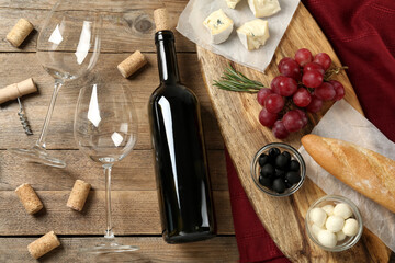 Fototapeta na wymiar Flat lay composition with red wine and snacks on wooden table
