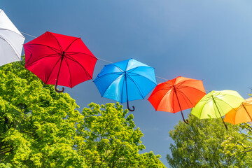 Colorful umbrellas as decoration in the park. Colorful umbrellas in the sky.