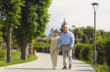 Active senior old couple walking in park talking enjoy time together. Older caucasian family staying in love spend day together. Elder healthy leisure lifestyle concept. Happy retirement and pleasure