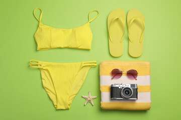 Flat lay composition with beach objects on green background