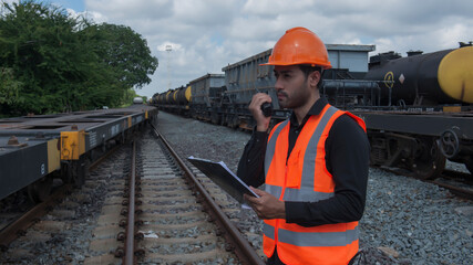 worker on the train. worker on the railway. Asian young engineer use radio communication on freight...