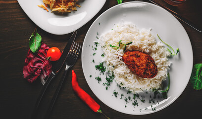 roasted burger with rice in white plate on wooden table background