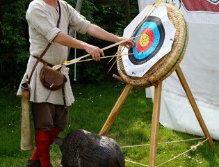 Closeup shot of a bowman getting bow arrows on a target