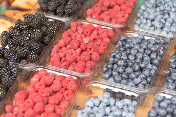 fresh berries are on sale. raspberries, blueberries, blueberries, blackberries