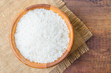 Organic Thai Jasmine rice grain in wooden bowl.