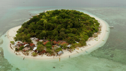 Tropical island and sandy beach surrounded by atoll and coral reef with turquoise water, aerial drone. Tropical island and coral reef. Summer and travel vacation concept, Camiguin, Philippines