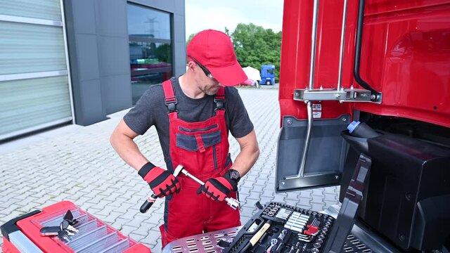 Caucasian Truck Mechanic Performing Vehicle Maintenance