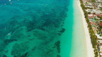 Tropical lagoon with turquoise water and white sand beach from above. Boracay, Philippines. White beach with tourists and hotels. Summer and travel vacation concept.