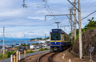 Fototapeta na wymiar 七里ガ浜の海岸沿いに富士山を見ながら走る江ノ電
