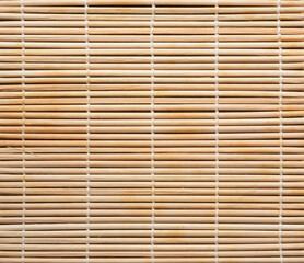 Texture of bamboo knitted with cotton thread. Cooking utensils for making sushi rolls. Beige bamboo background