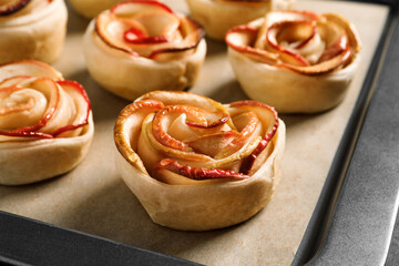 Tray with freshly baked apple roses, closeup view. Beautiful dessert