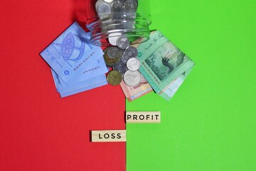 Image of coins, banknotes and wooden cube with text PROFIT LOSS on green, red background