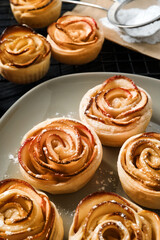 Freshly baked apple roses on plate, closeup. Beautiful dessert