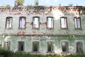 facade of an old ruined brick building with window openings