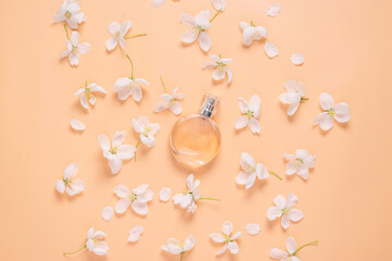 Perfume bottle and delicate flowers white petals pink background flat layout. Flower water floral natural background 