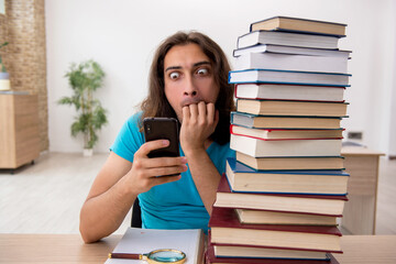 Young male student and a lot of books in the class