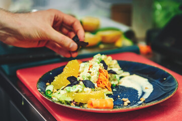 chef hand of cook making vegetables salad on kitchen