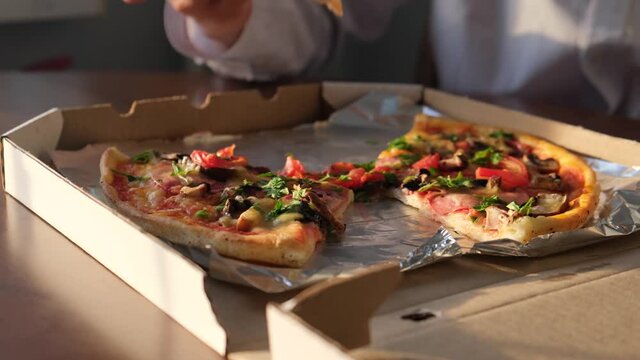 Man eating pizza received from the delivery service, close-up
