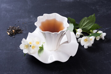 green tea with jasmine in white cup   on grey background, top view