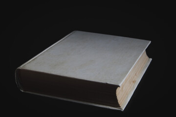 An old-fashioned book close-up with blank covers on a black background