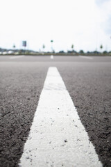 White line on dark asphalt close-up. Parking lines