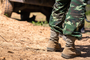A scene of infantryman or soldier commander is standing on the dust ground with blurred of vehicle...