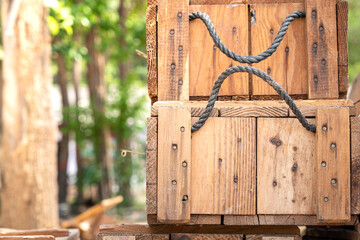 A traditional retro wood box crate for weapon, ammunition or armory items. There are stack together, with blurred background of jungle environment. Object photo.