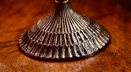 Metallic round object on wooden surface 