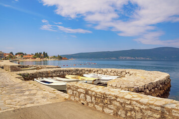 Fototapeta premium Beautiful summer Mediterranean landscape. Montenegro, Adriatic Sea. Coast of Bay of Kotor near Tivat city. Mandrac ( mandrach ) is stone jetty for fishing boats, cultural heritage in Kotor Bay.