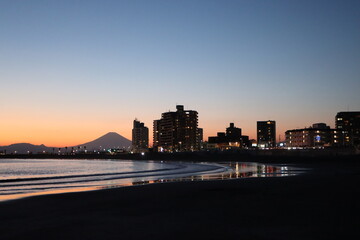 鎌倉腰越漁港防波堤から眺める日没直後の江ノ島の風景