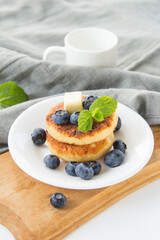A healthy breakfast of pancakes, berries, butter, and honey. Creative atmospheric decoration