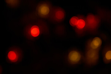 Defocused bokeh red and orange big lights on black background. Blurred abstract big red spots wallpaper for love theme, Valentine's day.