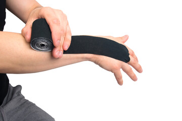the process of applying the black kinesio tape, to protect against injury when playing sports