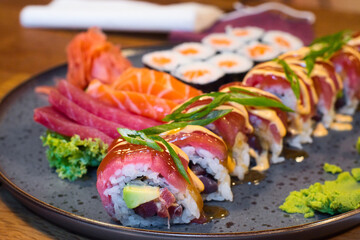 The variety of food showing the taste of Japan - mixed set of colorful seafood sushi, tuna, losos and shrimp nigiri, tempura and shrimp rolls