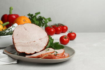 Delicious cut ham served with parsley on light grey table, space for text